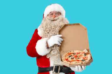 Mavi arka planda bir kutu lezzetli pizzayla Noel Baba