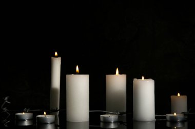 Karanlık arka planda dikenli telle mum yakmak. Uluslararası Soykırım Anma Günü