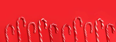 Kırmızı arka planda bir sürü Noel şekeri kamışı