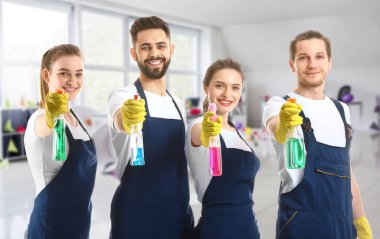 Partiden sonra dağınık ofiste deterjanla temizlik görevlileri.