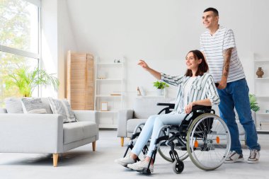 Genç adam ve karısı evde tekerlekli sandalyede.