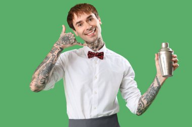 Genç barmen yeşil arka planda 