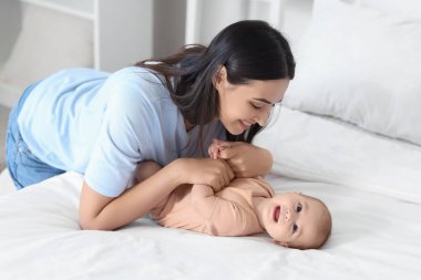 Mutlu anne ve küçük bebeği yatak odasında.
