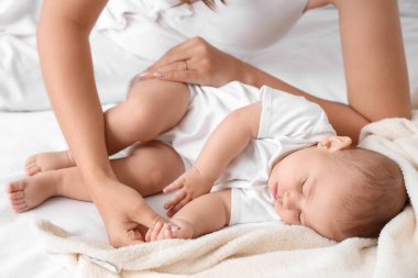 Mutlu anne ve uyuyan küçük bebeği yatak odasında, yakın plan.