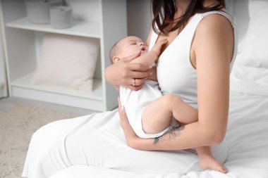 Mutlu anne ve uyuyan küçük bebeği yatak odasında.