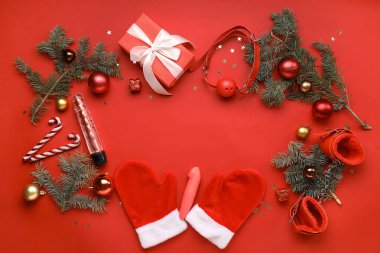 Seks oyuncaklarından yapılmış çerçeve, Noel süslemeleri ve kırmızı arka planda köknar dalları