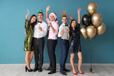 Mavi duvarın yanında şampanya içen bir grup arkadaş. Yeni yıl kutlaması