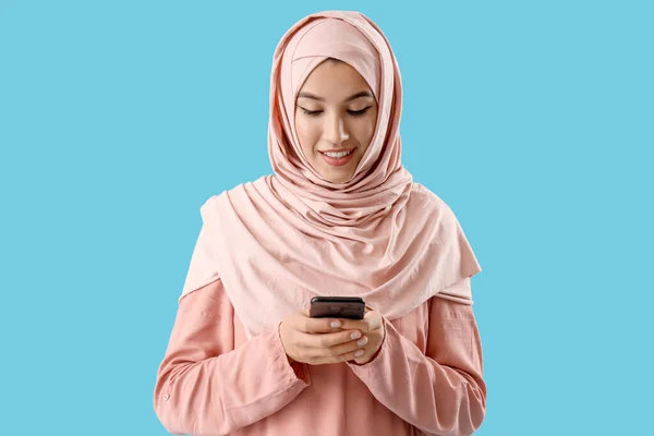 Hermosa Mujer Musulmana Con Teléfono Móvil Sobre Fondo Azul —  Fotos de Stock