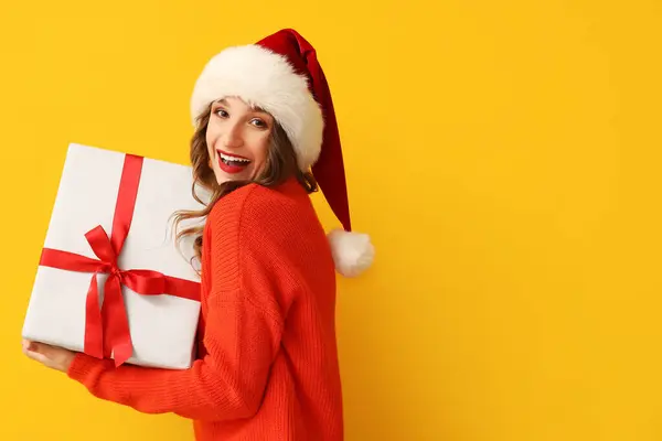 Happy Young Woman Santa Hat Christmas Gift Box Yellow Background — Stock Photo, Image