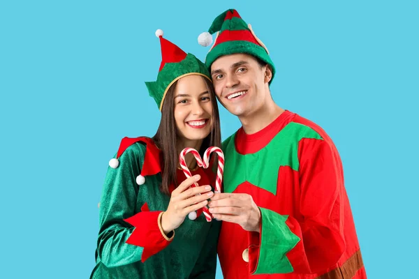 Glückliches Paar Elfenkostümen Mit Zuckerstangen Auf Blauem Hintergrund — Stockfoto