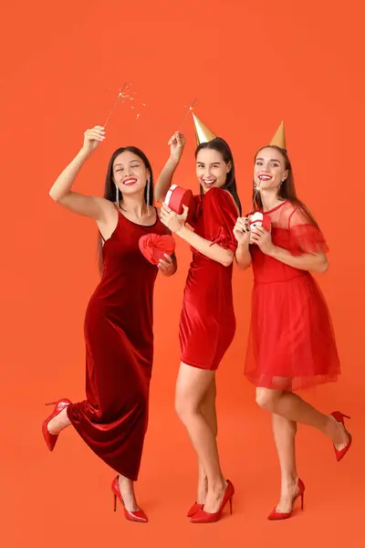 Красивые Молодые Женщины Подарками Оранжевом Фоне Новогодний Праздник — стоковое фото