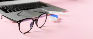 Pembe arka planda şık gözlükler, yakın plan.