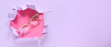 Yırtık kağıttan görünen gözlüklerle eflatun arkaplan ve metin için boşluk