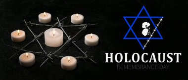Burning candles and barbed wire in shape of David star on dark background. International Holocaust Remembrance Day