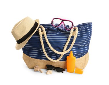 Beyaz arka planda izole edilmiş plaj aksesuarlarıyla bir şişe güneş kremi.