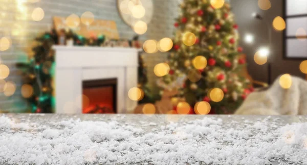 Empty wooden table with snow in room decorated for Christmas