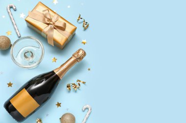 Şampanyalı, altın madalyalı ve açık mavi arkaplanlı güzel bir yeni yıl partisi kompozisyonu..