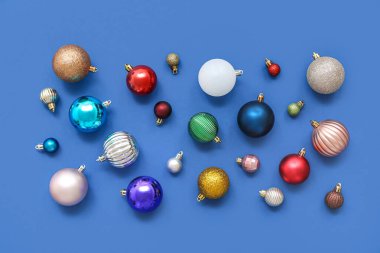 Mavi arka planda Noel topları olan kompozisyon