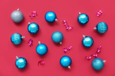 Kırmızı arka planda Noel topları ve kurdeleleri olan kompozisyon