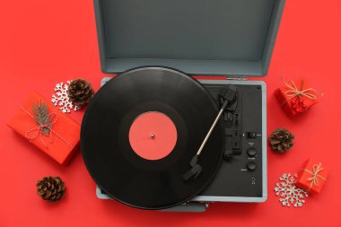 Kırmızı arkaplanda plak çalar ve Noel süslemeleri