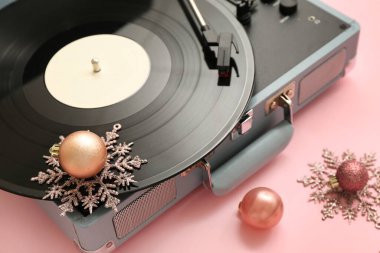 Pembe arka planda Noel süslemeleri olan vintage turntable