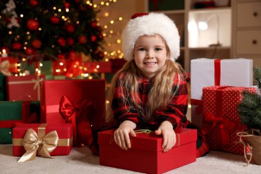 Noel Baba şapkalı şirin küçük kız ve evde Noel hediyeleri.