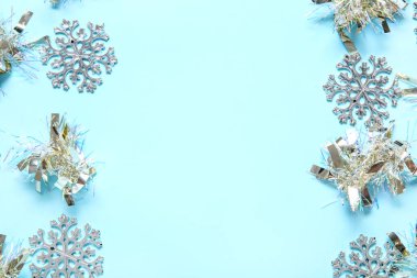 Renkli arkaplanda Noel süsleri ve kar taneleri olan kompozisyon