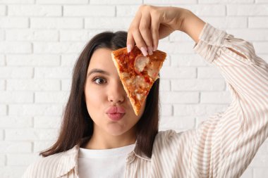 Beyaz tuğlalı lezzetli pizzası olan genç bir kadın.