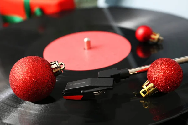 Christmas music concept with red balls on vinyl record turntable