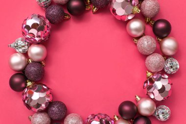 Pembe arka planda Noel ağacı toplarından yapılmış çerçeve