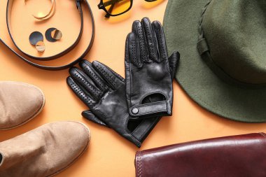 Siyah deri eldivenli kompozisyon, kadın aksesuarları ve renkli arka planda ayakkabılar.