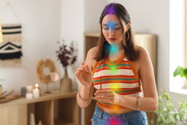 Evinde tütsülenmiş yer ve aura temizleyen genç bir kadın.