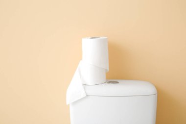 Kağıt tuvalet tankının üzerinde renk arkaplanına karşı rulo, yakın plan