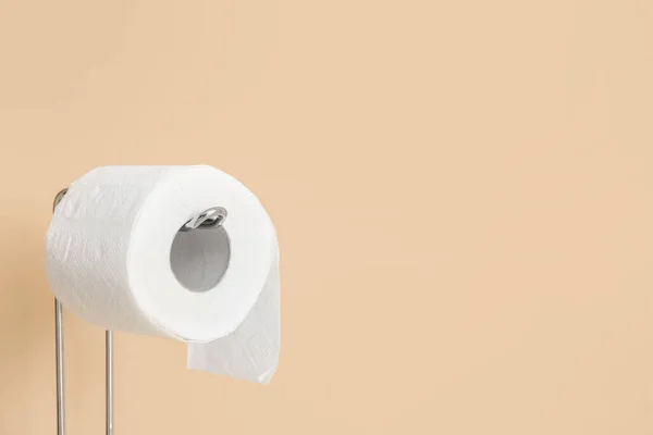 Holder with toilet paper roll near color wall, closeup