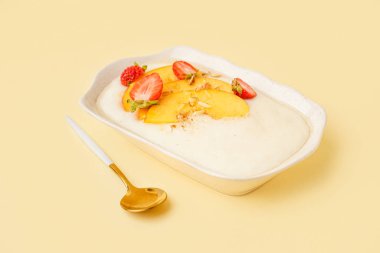 Bir kase leziz irmik lapası nektarin ve sarı arka planda böğürtlen.