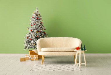 Güzel Noel ağacı hediye kutuları ve yeşil duvarın yanındaki kanepe