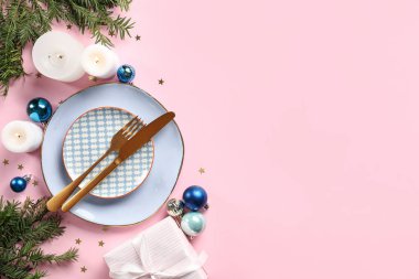 Pembe arka planda süslemeleri olan güzel bir Noel yemeği masası.