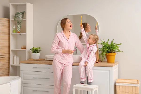 幸せな母親と彼女の小さな娘は バスルームに歯ブラシを持っています — ストック写真