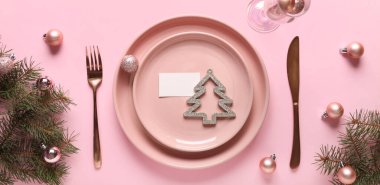 Pembe arka planda güzel bir Noel masası.