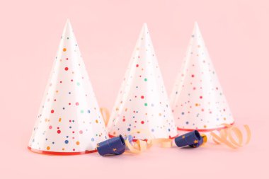 Renkli arka planda parti şapkaları, düdükler ve yılanbalığı