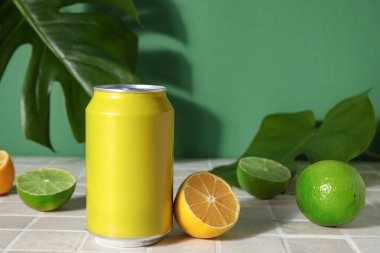 Yeşil duvarın yanındaki masada turunçgil meyveli soda ve palmiye yaprağı var.