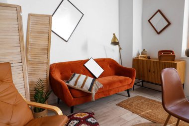 Dağınık odada duvardan düşmüş bir kanepe.