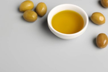 Gri arka planda taze zeytinyağlı kase