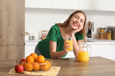 Bardak portakal suyu mutfak olan kadın