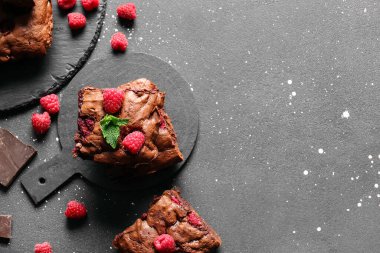 Siyah masanın üzerinde ahududulu çikolatalı browni var.