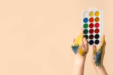 Bej arka planda renkli suluboya boyalı kadın elleri