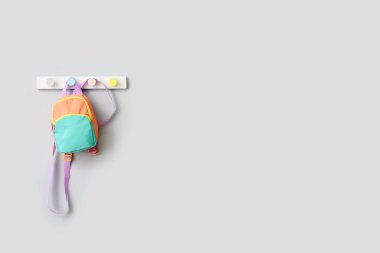 Işık duvarında asılı şık okul çantası