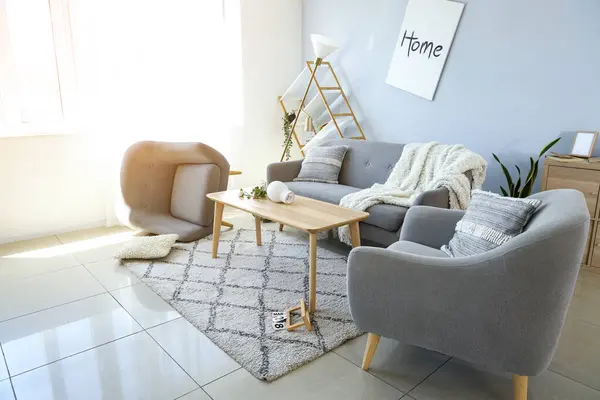 Sofa with armchairs and table in messy living room