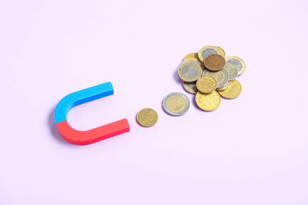 ライラックの背景にコインで磁石 投資コンセプトの魅力 — ストック写真