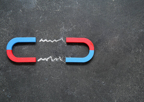 Creative composition with attracting magnets on grunge black background.